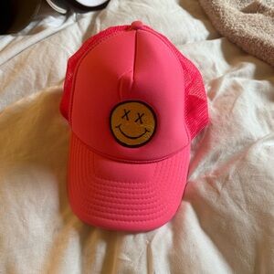 Neon pink smiley face trucker hat